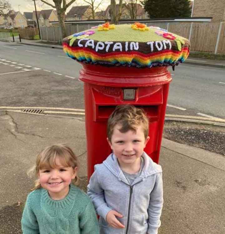 Oliver and Jessica Langford by the post box topper knitted by their gran.