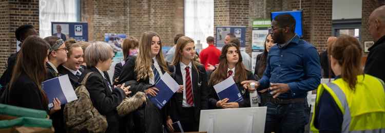 Trainee assistant engineer Titus Simpamba, talking to local secondary school children at The Port of Tilbury's Recruitment Day held in The London Cruise Terminal