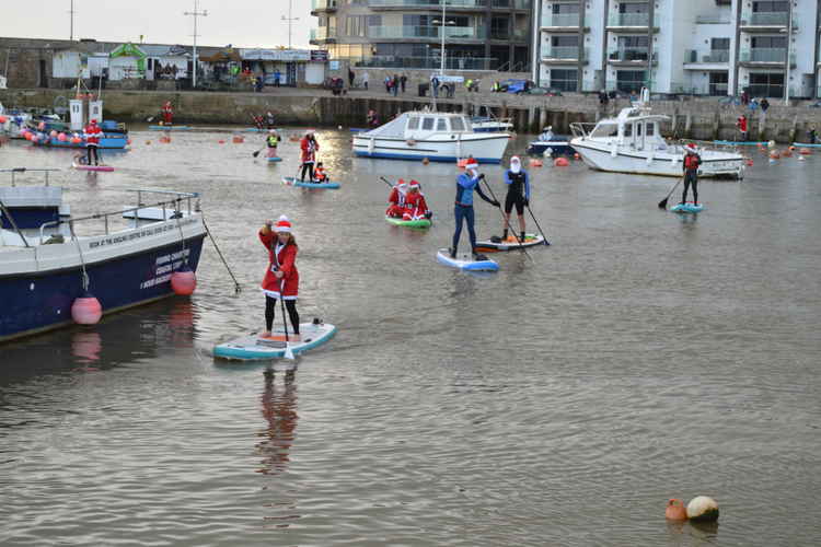 The Santa paddle boarders in West Bay harbour