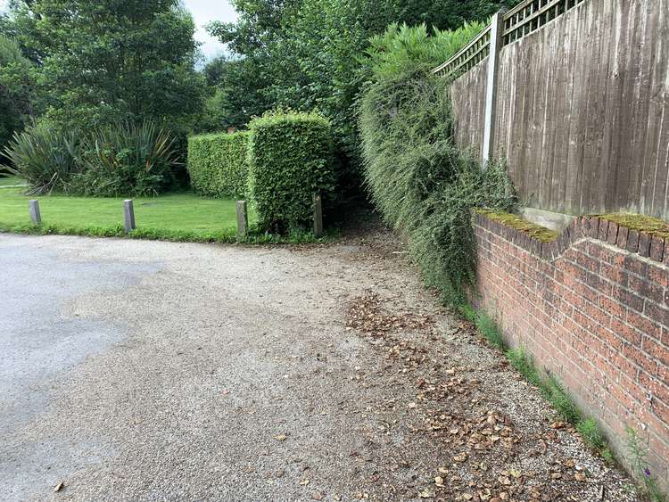 As you reach a line of garages there will be a small path in front of you between a wall and hedge