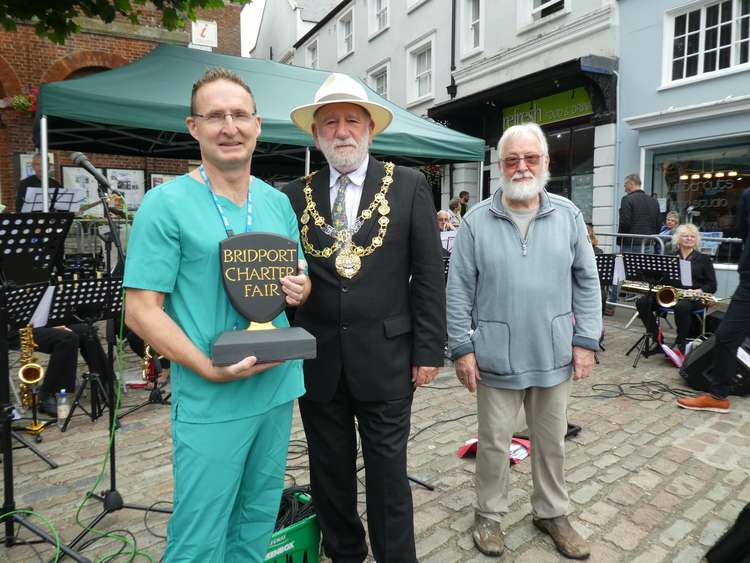 Dr Andrew Finucane receives the Bridport Charter Fair Award from Bridport mayor, councillor Ian Bark, and charter fair chairman Arthur Woodgate on behalf of all those who helped with vaccinations in the area