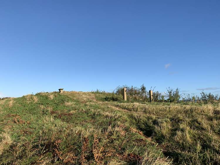 When you reach the top of the hill, turn left to walk towards a small concrete bench