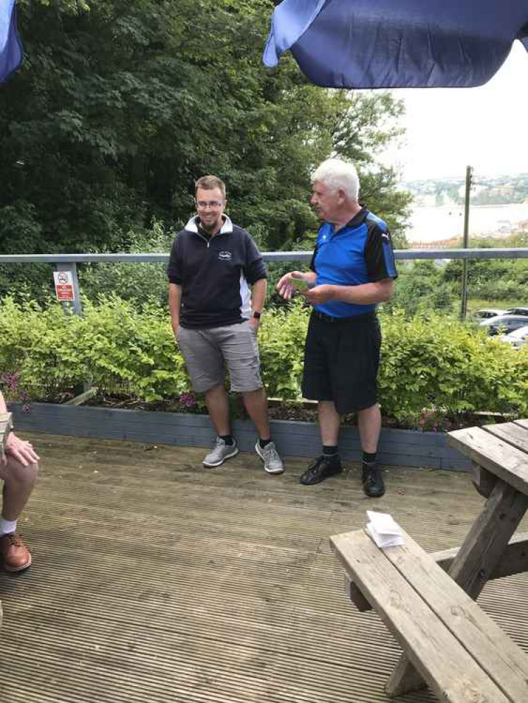 Senior's Captain John Hannah makes a presentation to bar manager Andy Jeffrey on veranda outside the Axe Cliff clubhouse