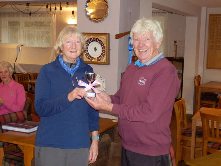 Ladies' captain Anne Jarvis receives the Courtesy Cup at Axe Cliff from seniors' captain John Hannah. Photo by Rob Grove