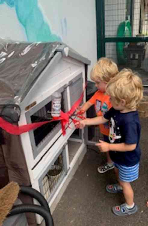 Children from Colyton Caterpillars open their new rabbit hutch