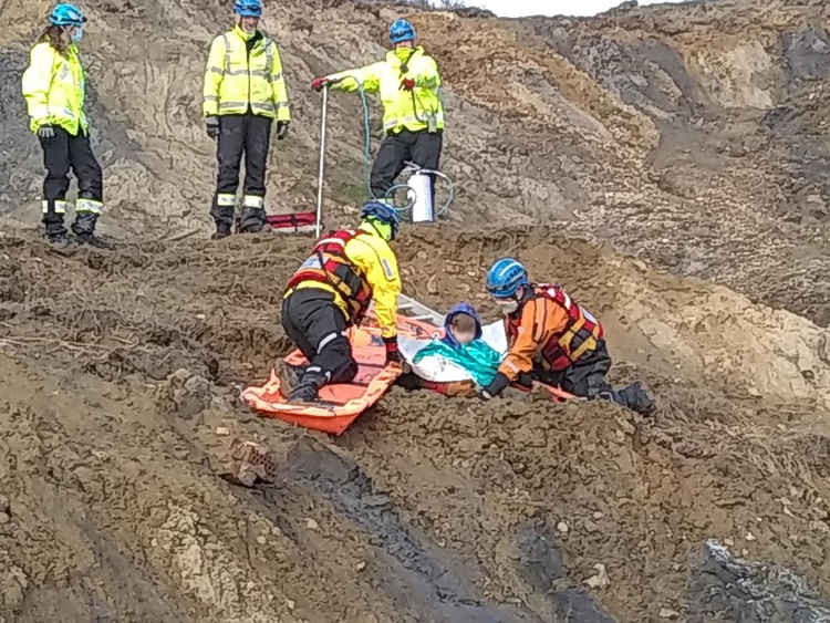 Coastguards work to rescue the boy from mud in Charmouth (photo credit: Colyton Fire Station)