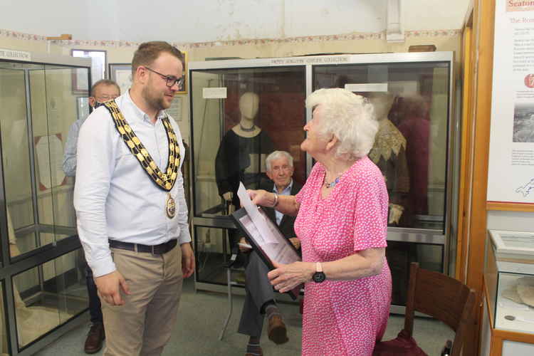 The Mayor of Seaton, Cllr Dan Ledger, presents June Richards with a life membership of the Axe Valley Heritage Association