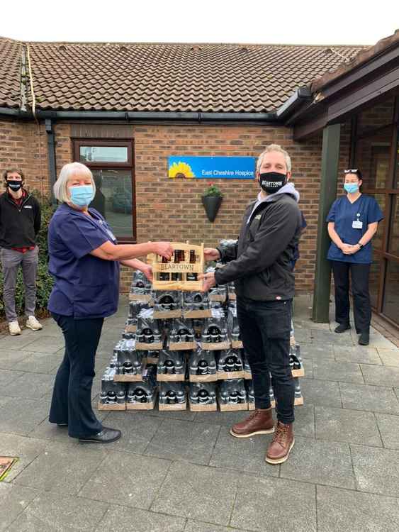 East Cheshire Hospice Clinical Director Sandra Jones receives a beer supply from Joe Manning, Managing Director of Beartown Brewery.