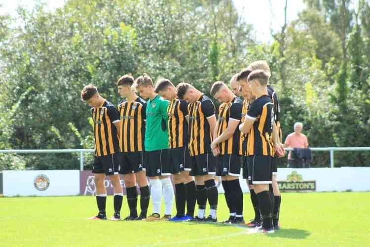 Axminster Town players in a minute's silence in memory of stalwart Jonny Broom