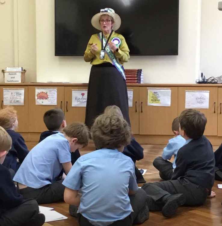 Susan Munro, chair of Elizabeth's Group telling children about Mrs Elmy at Astbury St. Mary's Church of England Primary School