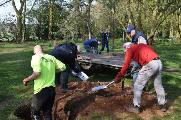 Council staff and volunteers from the arboretum prepare the ground for planting.