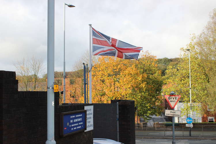 The Union Jack flag flies outside the police car only entrance at Congleton Police Station.