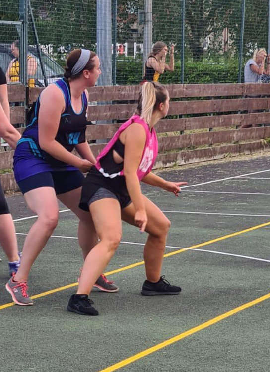 Rosie on the netball court in the pink shirt