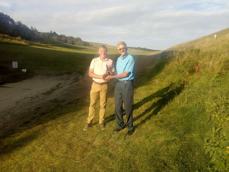 Nick Sellick (left) passes the inter-club cup to Peter Jakes on the first hole at Axe Cliff