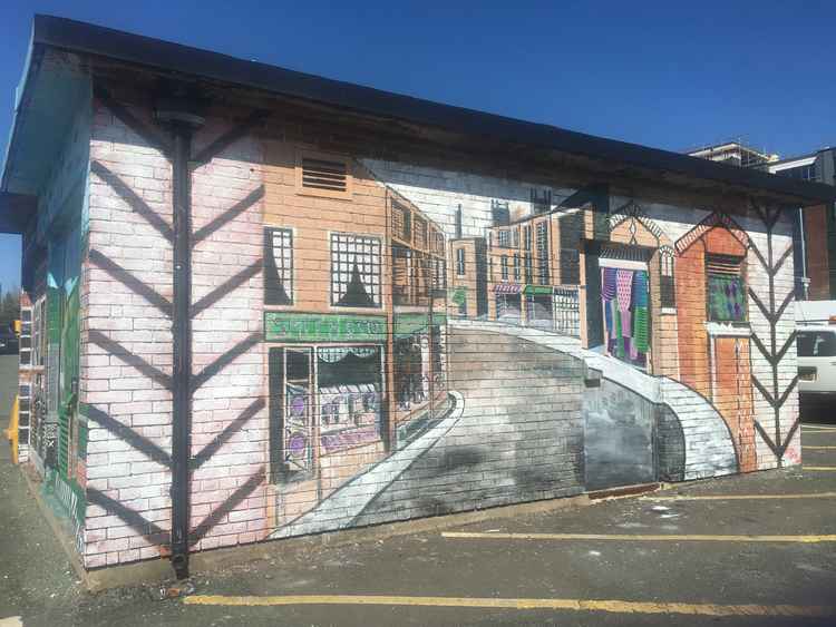 While the murals were designed to be viewed from a distance, they are a gorgeous sight up close. This south-facing side shows a stylised representation of Mill Street from Market Place.