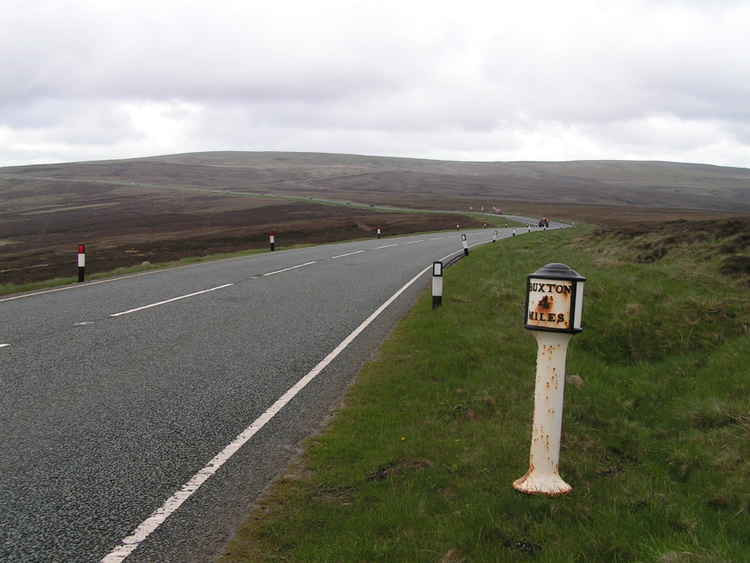 Macclesfield's Cat and Fiddle Road is formed by parts of the A537, and is one of the local areas to benefit by the new road safety initiatives. This Grade II listed iron milepost reads "Buxton 4 miles, Maccl [Macclesfield] 7¾ miles. (Image - bit.