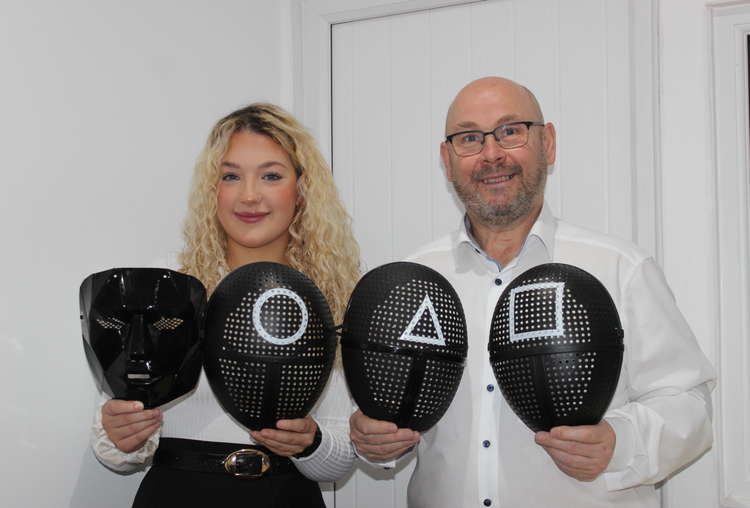 A Macclesfield company has brought 'Squid Game' masks to Macclesfield, just in time for Halloween. Pictured is Abbey Festive Decor's Megan Jones and Scott Hulme with the masks.