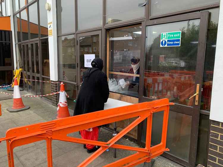 A woman collects a food package from outside the Gurdwara. Image Credit: Sri Guru Singh Sabha Southall