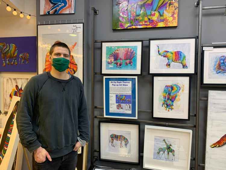 Raph Thomas standing proudly next to his artwork in the pop up gallery in Ealing Broadway, prior to the third lockdown