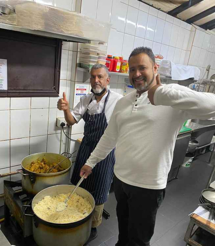 Haweli owner, Manik Miah (right) cooking the food