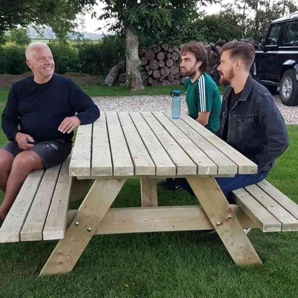 Axminster Property managing director Ian Styles pictured at one of the seven benches he has made for Axminster's Community Waffle House customers on the Minster Green