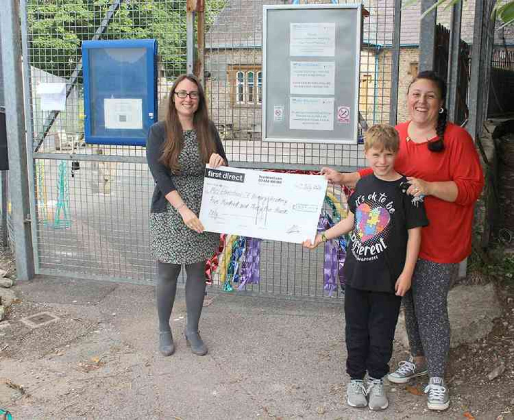 Zishan Adamson-Drage and son Jacob present a cheque to Miss Lyons of Mrs Ethelston's Primary School