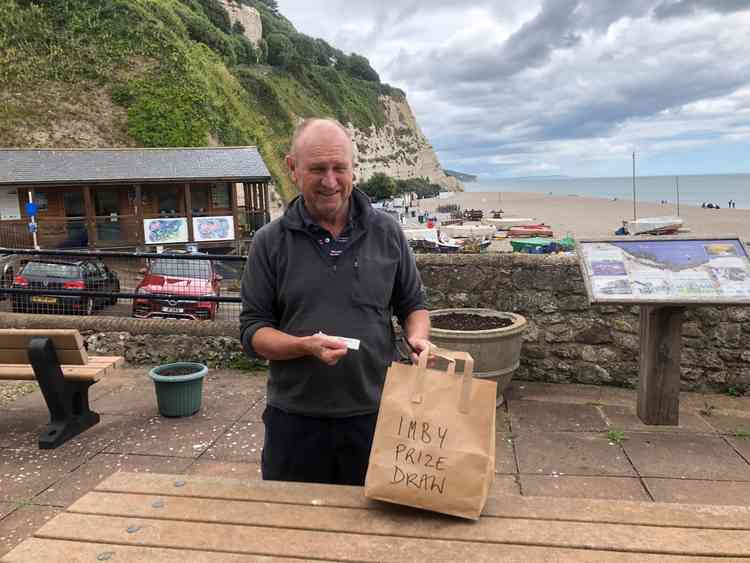 Councillor Geoff Pook selecting the winner of the In My Back Yard food box