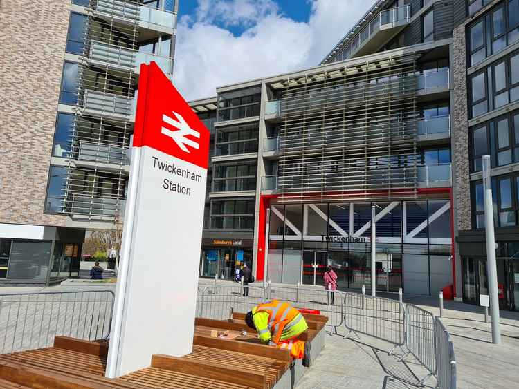 A contractor instals benches with a sign in the middle