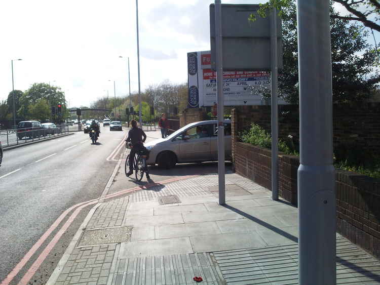 Near miss: A cyclist is nearly hit by a car on Twickenham Road at the London Scottish Rugby Club car park exit in 2010 (Image: RichmondCycling)