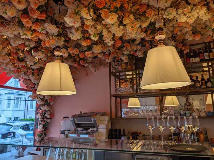 Gorgeous flowers line the ceiling above the bar. The restaurant's decor is inspired by Mayfair Club Annabel's (Image: Ellie Brown)