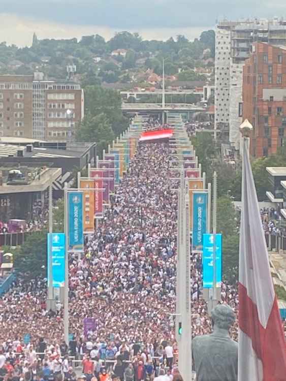 A river of people en route to Wembley for the Euro 2020 final with a giant England flag, and the Bobby Moore sculpture in the foreground (Image: Stuart Higgins)