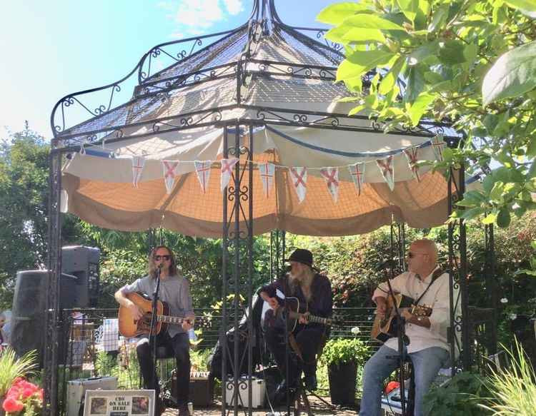 Steve Black, Alan West and Adam Sweet performing at a "Music In The Garden" event in 2019