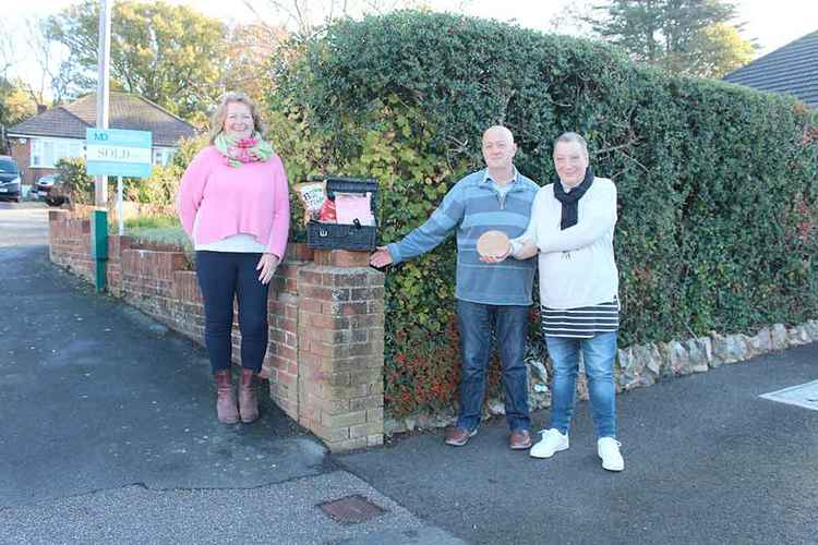 Mary Kahn presents the luxury hamper prize to Nigel and Karen Ball, who first thought of the idea for the beach hut