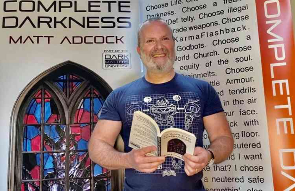 Successful Hitchin author Matt Adock with his book Complete Darkness