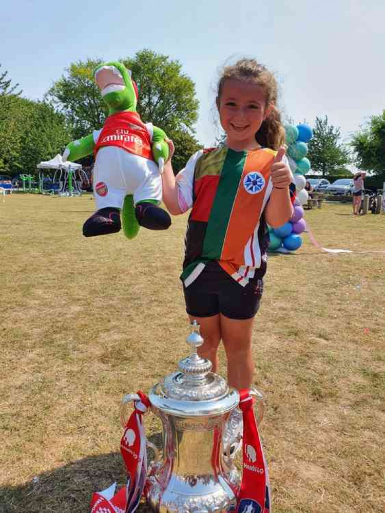 Inspirational Betty Leigh-Allinson with the FA Cup and her beloved Gunnersaurus. CREDIT: HITCHIN NUB NEWS