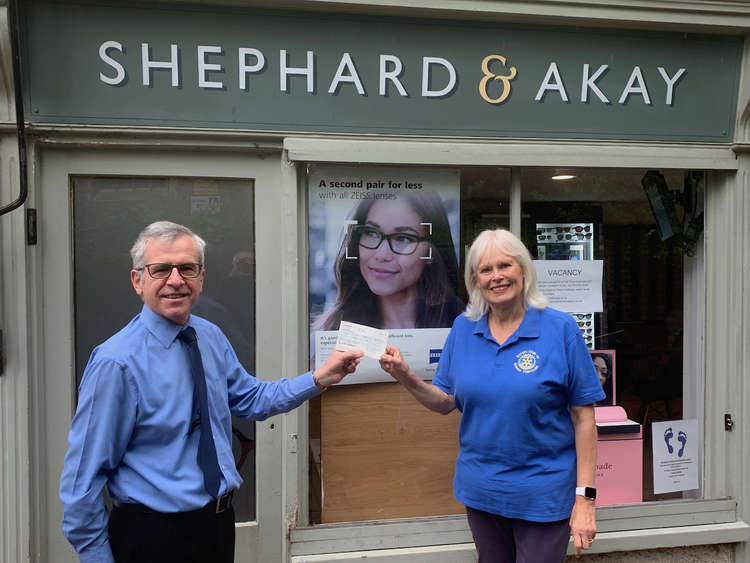 Tilehouse member Stella Farr accepts a cheque from Ali Akay of Hitchin opticians Shephard & Akay