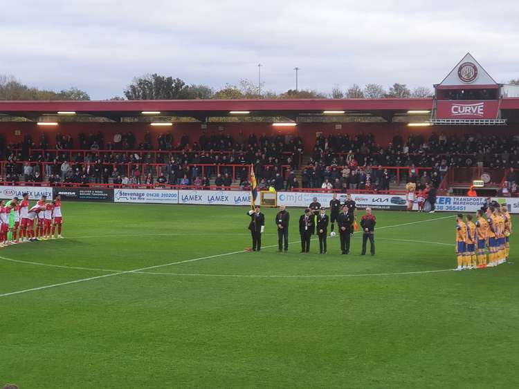 Stevenage and Mansfield players pay their respects to the fallen before kick-off as the Last Post is played. CREDIT: @laythy29