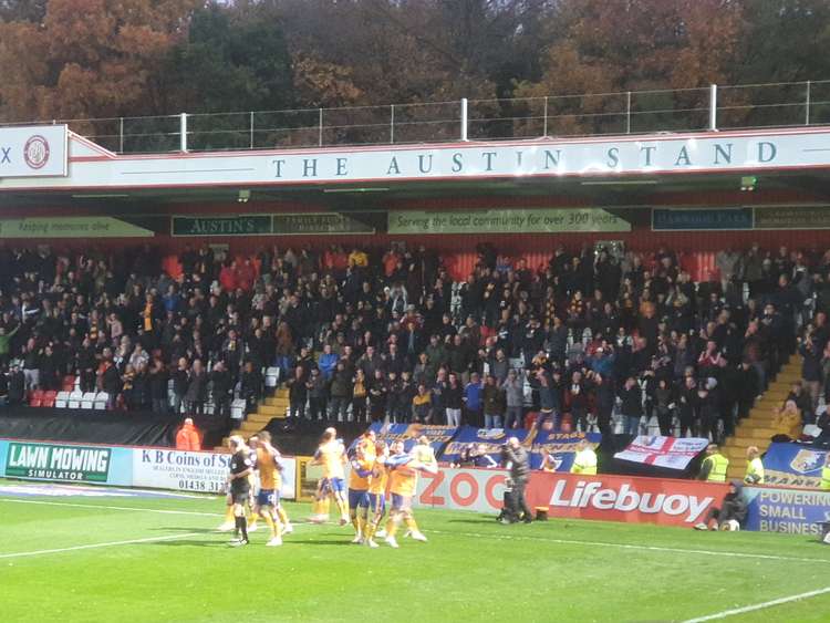 Mansfield Town players celebrate with their travelling fans after Ryan Stirk's winner. CREDIT: @laythy29