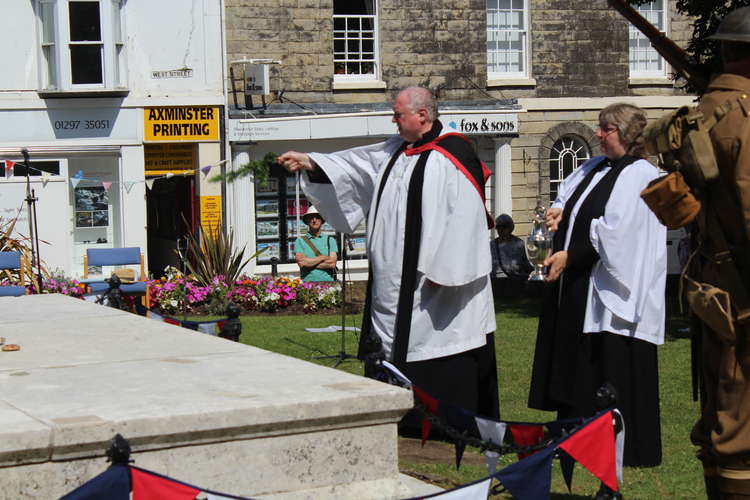 The Rector of Axminster, the Reverend Clive Sedgewick, rededicates the war memorial, assisted by the assistant curate, the Reverend Tracey Voysey