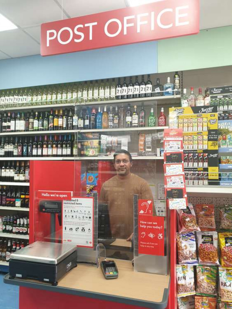 Newly trained post master and Food Link owner and manager Miki Shah on the desk. (Image: Hannah Davenport)
