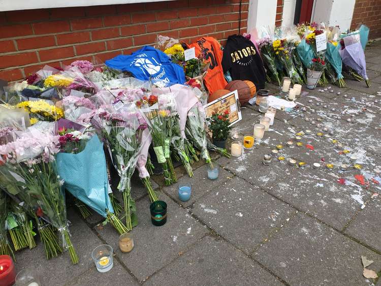 Flowers, candles, messages and basketballs have been laid out in dedication to Ali.