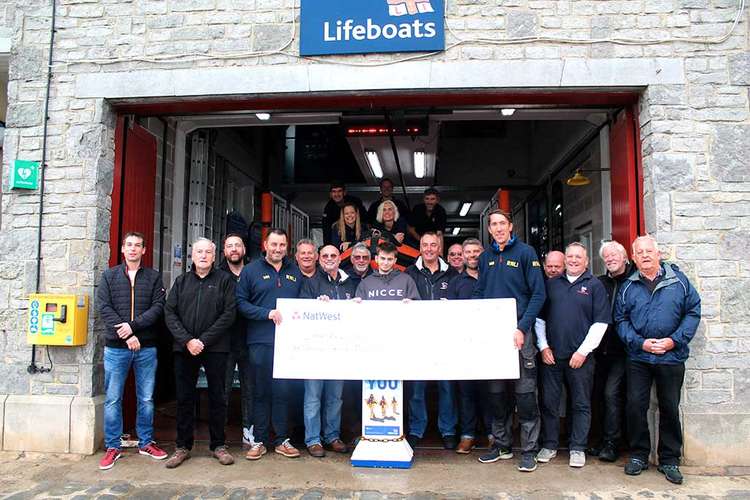 Family members of the late Adam Bounds hand over a cheque for just over £1,700 to Lyme Regis lifeboat crew