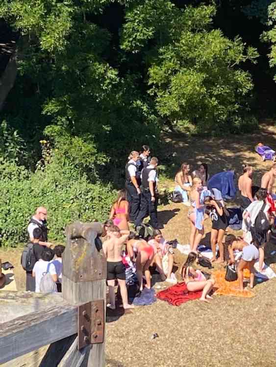Police mingle amongst the sunbathers urging them to move on