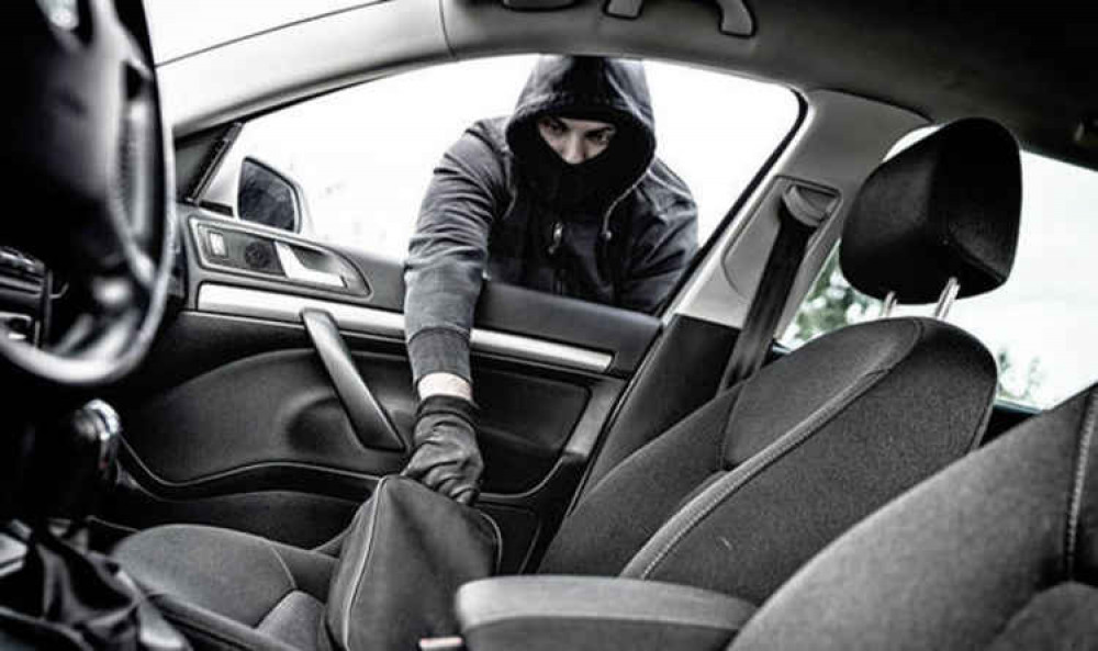 A thief breaking into a car