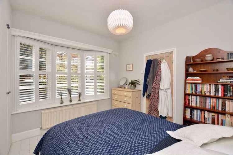 The main bedroom has a bay window with views of the property's walled garden