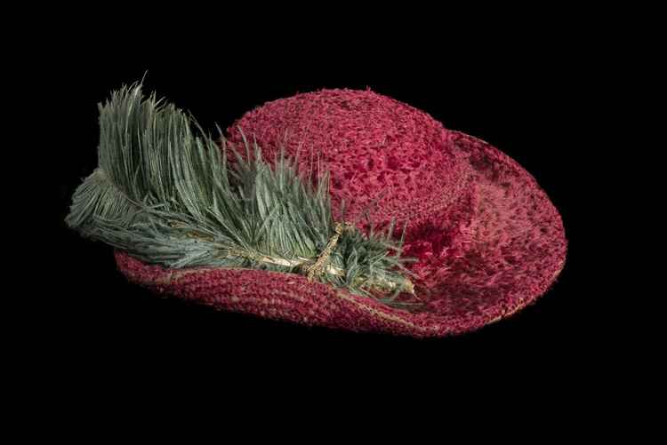 A photo of Henry VIII's Bristowe hat which is red silk and silver with a green ostrich feather / Credit: © Historic Royal Palaces