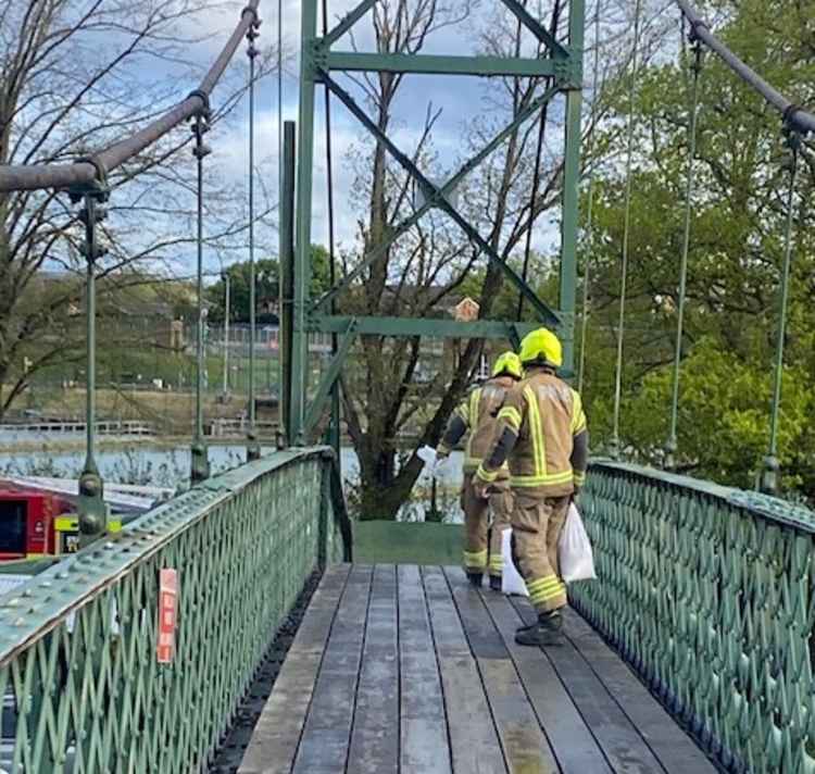 Two firefighters on their way over the island's footbridge