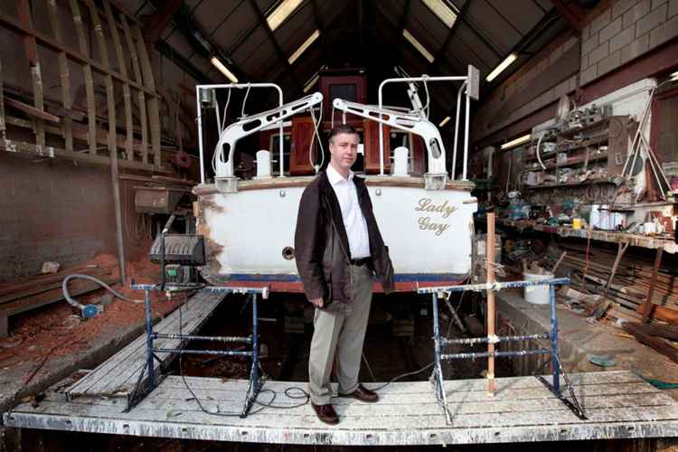 Owner Jason Carley pictured with the 78-year-old yacht The Lady Gay, which he has restored