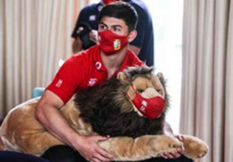 Wales' flying winger Louis Rees-Zammit is presented with BIL, the official mascot of the British & Irish Lions at The Lensbury