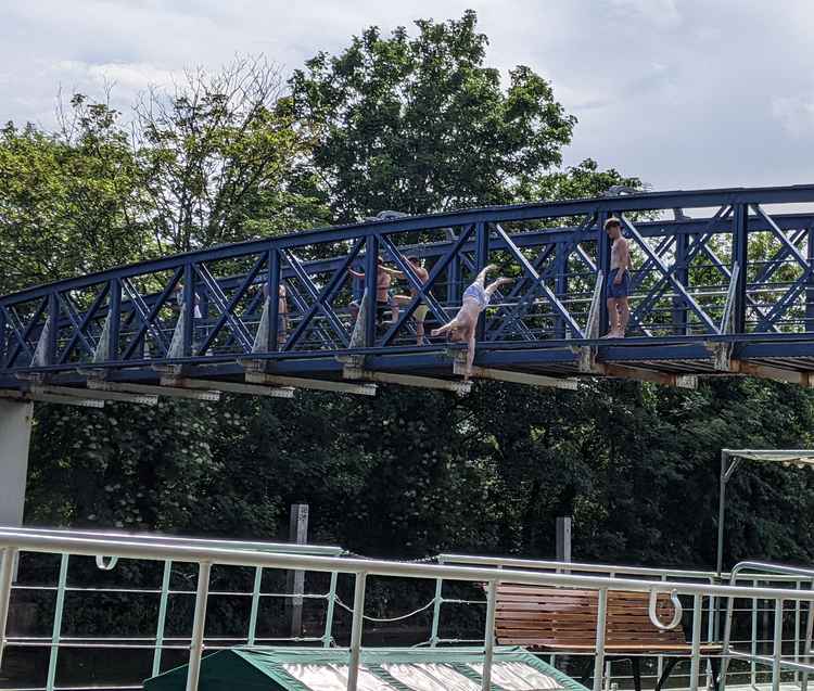 A boy dives off the Lock bridge. Teddington RNLI has warned that this activity is dangerous